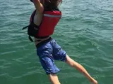 Young guest jumping into the water off Mowana Yacht